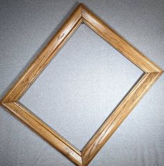 an empty wooden frame on a gray surface