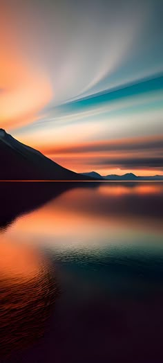 the sky is reflected in the still water at sunset with mountains and clouds behind it