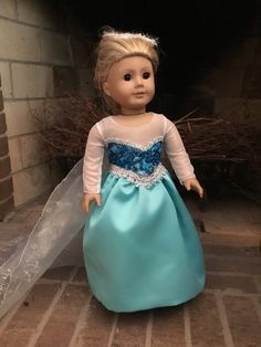 a doll is dressed in a blue dress