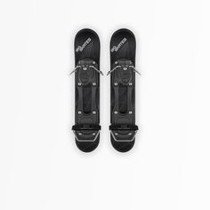 two black snowboards are shown on a white background, one is facing the camera