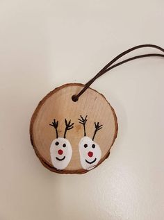 a wooden ornament with two reindeer faces on it