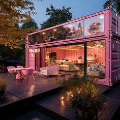 a pink shipping container sitting on top of a wooden deck next to a table and chairs