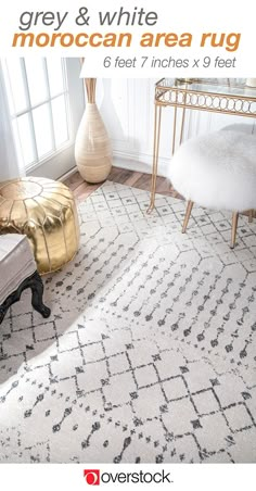 a white rug with black and gold accents in a living room next to a window