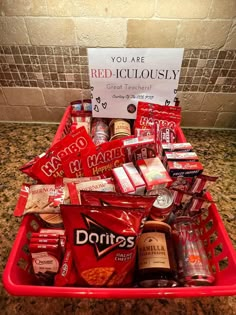 a red basket filled with lots of food and drinks