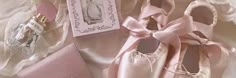 there is a pair of pink ballet shoes next to an empty card and box on the bed