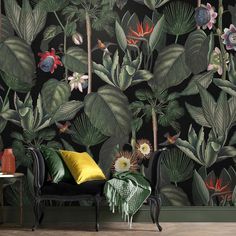 a living room with wallpaper that has tropical plants and flowers on it, along with a black couch