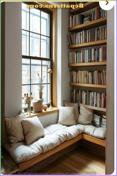 a window seat in front of a bookshelf filled with books