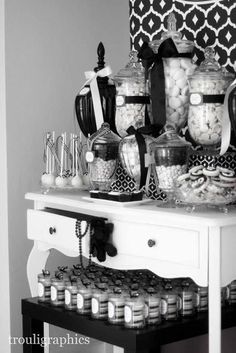 black and white photograph of candy bar with candies in jars on the top shelf