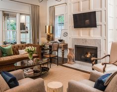 a living room filled with furniture and a flat screen tv mounted on the wall above a fireplace