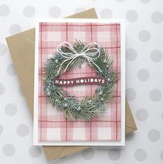 a handmade christmas card with a wreath on it and the words happy holidays written in red