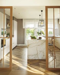 an open kitchen with marble counter tops and wooden floors