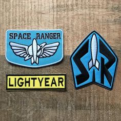 space ranger and lightyear patches on a wooden surface with the word space ranger written below them