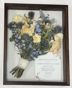 a bouquet of flowers is displayed in a frame