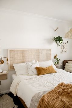 a bed with white sheets and brown pillows