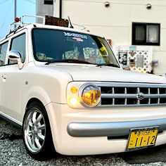 a white truck parked in front of a building with a yellow license plate on it