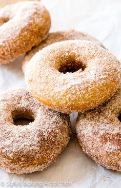 four sugared donuts are stacked on top of each other