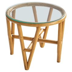 a round glass table with wooden legs