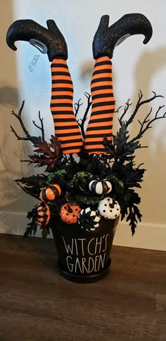 a witch planter with black and orange striped stockings