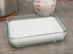 a glass container filled with milk sitting on top of a counter