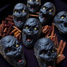 five black skulls with yellow eyes surrounded by cinnamon sticks