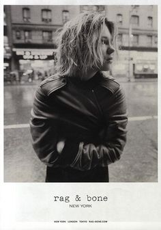 a black and white photo of a woman standing in the street