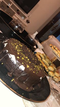 a chocolate cake sitting on top of a table next to other desserts and pastries