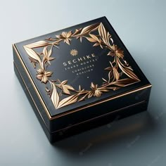 a black and gold box with flowers on the lid that says schne chocolate couture