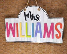 a wooden sign that says mr and mrs williams hanging on a wall next to a chicken wire fence