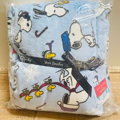 a bag with snoopy on it is sitting on the floor in front of a wall