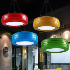 three colorful lights hanging from chains in a room