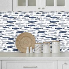 a kitchen with white cabinets and blue fish wallpaper