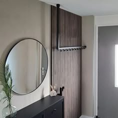 there is a mirror on the wall next to a dresser in this room with a black cabinet