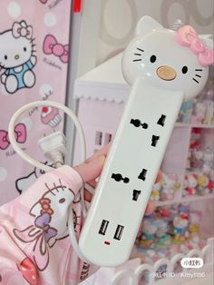 a hello kitty cell phone charger is being held up