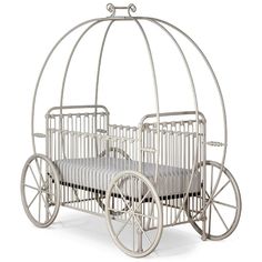 an old fashioned baby's carriage that is white and has wheels on the side