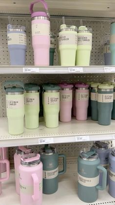 many different colored coffee mugs on shelves in a store