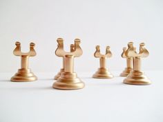 four brass chess pieces are lined up in a row