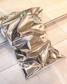 a pile of silver foil sitting on top of a tiled floor