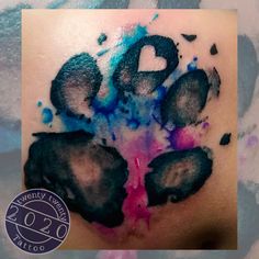 a tattoo with the letter b painted on it's chest and paw prints in blue, pink, and black ink