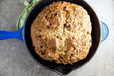 a freshly baked bread in a skillet on a counter top with a blue spatula