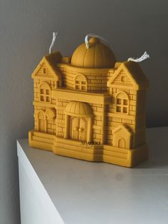 a small yellow building with a dome on top and two birds perched on the roof