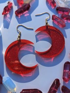 These ruby-red crescent moons are made of a richly colored glitter acrylic and almost glow as light shines through them. Super lightweight and make a great statement!  Available in a small and large version. Interested in a more subtle moon? Check out the clear rainbow iridescent moons on my shopfront, along with other colors! These earrings are approximately 2" long (small) and 2.5" long (large). ★ GIFT-BOX & WRAPPING AVAILABLE IN CHECKOUT ★ SWAP CLOSURE TYPE: fish hook, lever back, and studs a Red Plastic Earrings For Gift, Red Plastic Party Jewelry, Red Glitter Jewelry For Party, Handmade Red Plastic Earrings, Handmade Crescent Jewelry For Parties, Plastic Round Jewelry For Parties, Round Plastic Party Jewelry, Crescent Shaped Pierced Jewelry For Parties, Crescent Shaped Jewelry For Parties