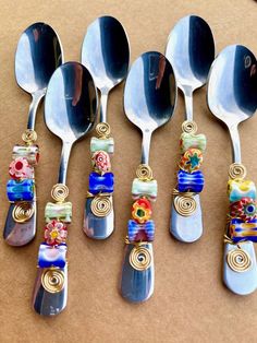 six spoons with different designs on them are lined up next to eachother