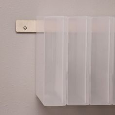 three clear plastic bags hanging from a hook on a white wall with a metal clip