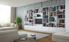 a living room filled with white furniture and bookshelves next to a large window