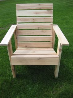 a wooden chair sitting on top of a lush green field