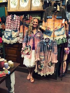 a woman standing in front of some shirts