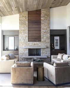 a living room filled with furniture and a fire place in the middle of a room