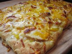 a cheesy pizza sitting on top of a wooden cutting board