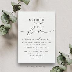 a white wedding card with the words nothing fancy just love on it next to some green leaves