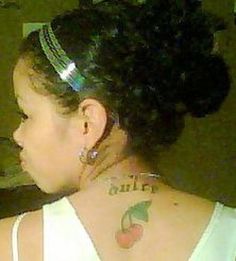 the back of a woman's head with an apple tattoo on her upper half